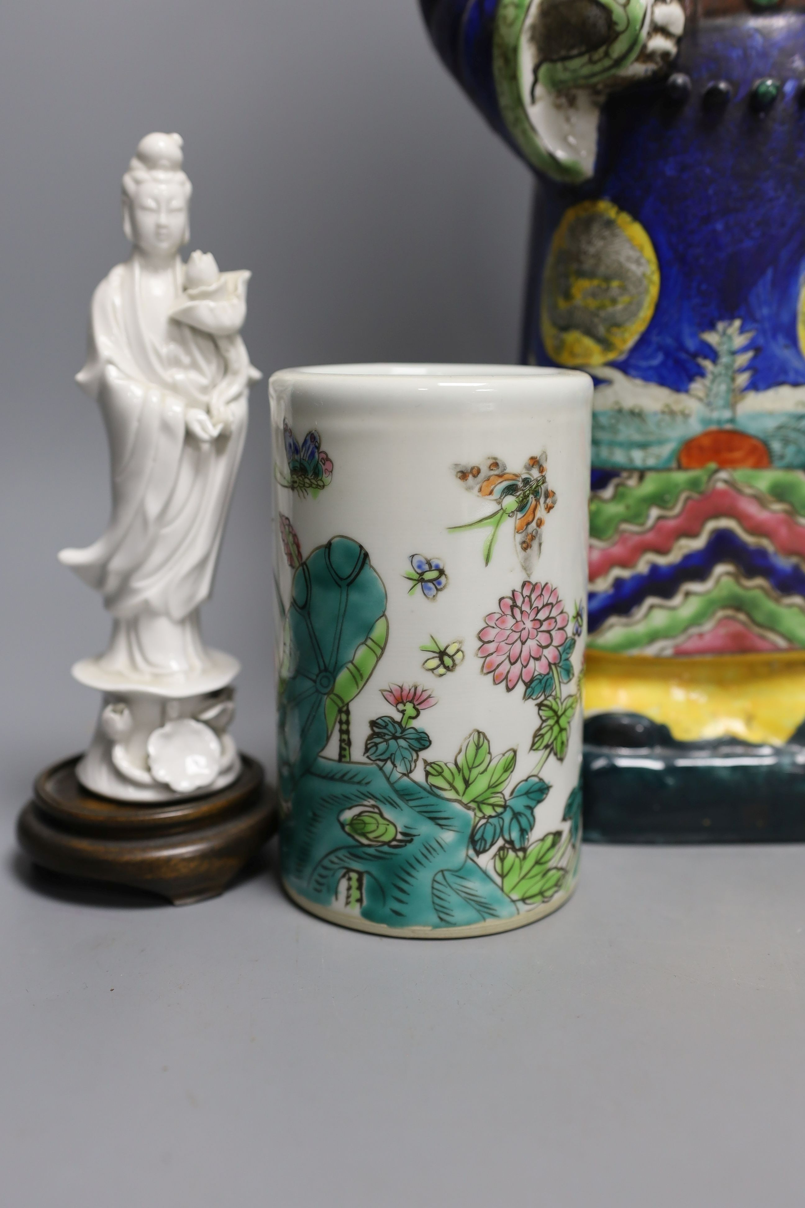 A Chinese brush pot, a pair of blanc de chine deities, a famille rose early 20th century figure, and a Kangxi emperor brush holder (5) - 45cm tall